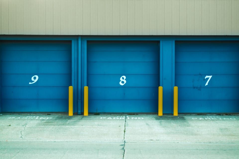 Two blue roll-up doors of a service bay