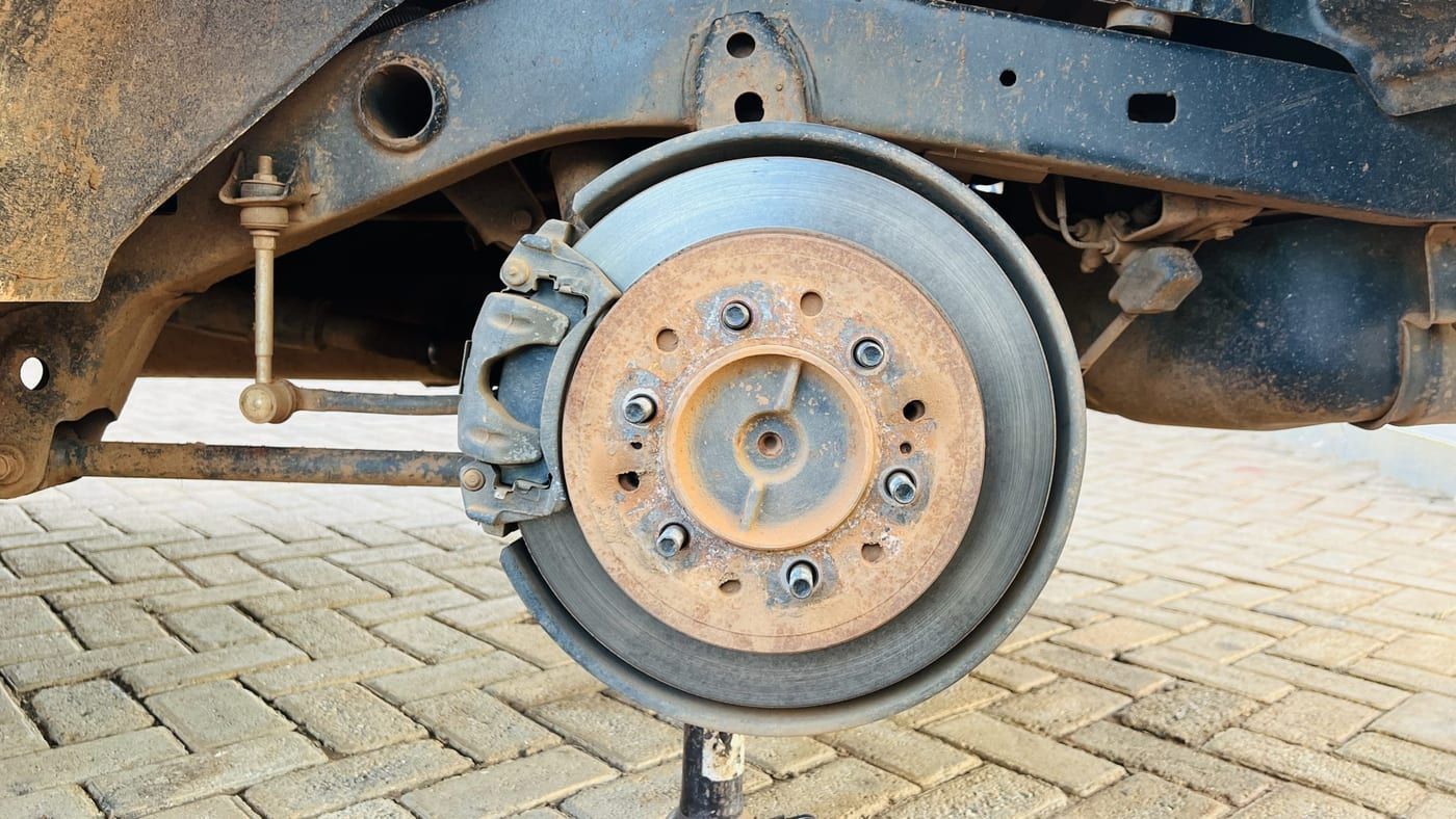 A brake rotor and caliper on a car with the wheel removed